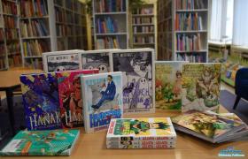 Książki stoją ustawione na stoliku