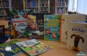 Pięć książek stoi na stoliku, a dwie leżą