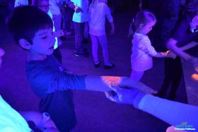 Chłopiec stoi i trzyma rękę przed siebie