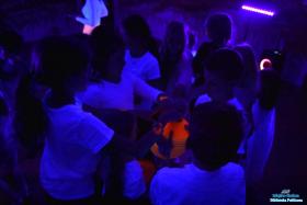 Chłópiec trzyma kolorowe kółka, a dzieci biorą od niego