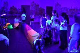 Pani trzyma tunel a dzieci przechodzą przez niego