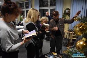 Kilka pań trzymających książki i pan podnoszący rękę do góry