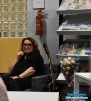 Kobieta-siedzca-na-fotelu-obok-niej-stoi-gitara-klasyczna