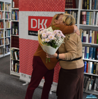 Pani wręcza bukiet kwiatów drugiej Pani