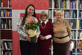 Trzy Panie stoją a jedna Pani trzyma kwiatka