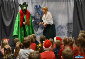 Dwie osoby w przebraniach stoją przed dziećmi