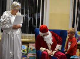 Mały chłopiec rozmawia z Mikołąjem i Panią w białej sukience