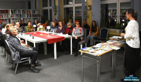 Zebrani goście siedzą a Pani stoi i wygłasza prelekcję