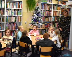 Pani rozmawia z dziećmi, które siedzą przy stoliku