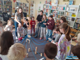 grupa dzieci z Panią stoi w kółu i trzyma zabawkę