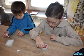 Dwóch chłopców miesza wykałaczkami kolorowe mydełka