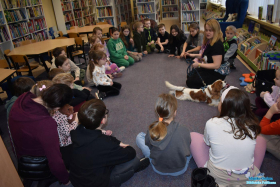 Pani z pieskiem oraz dzieci siedzą na dywanie