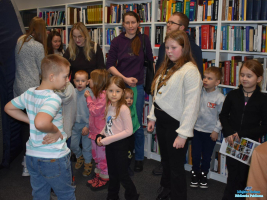 Grupa dzieci wraz z rodzicami czekają na kolejny seans w namiocie