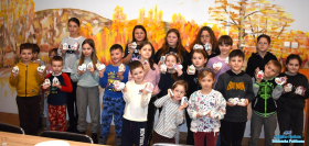 Dzieci pozują do zdjęcia oraz prezentują swoje prace