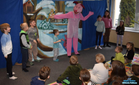 Aktor w przebraniu prosiaczka stoi wraz z dziećmi