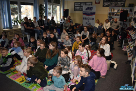 Dzieci z rodzicami siedzą na podłodze