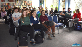 Goście zgromadzeni na spotkaniu siedzą na krzesłach