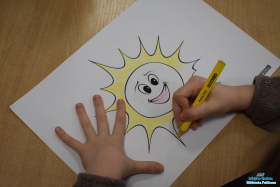 Dziecko koloruje słoneczko