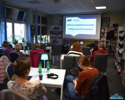 Zebrani podczas spotkania siedzą przy stolikach