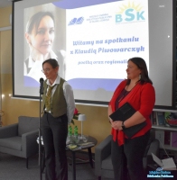 Dwie Panie stoją na tle slajdu