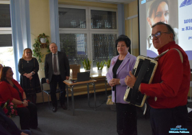 Pani gra na akordeonie a Panie stoją obok