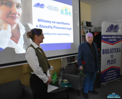 pan stoi trzyma różę, a obok stoi Pani