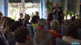 pan trzyma mikrofon i mówi do zebranych