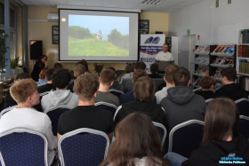 Pan stoi i mówi, a młodzież siedzi na krzesłach