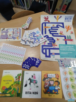 Plakaty książki oraz zakładki leżą na stoliku