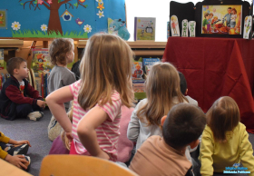 Dzieci siedzą i słuchają jak Pani czyta