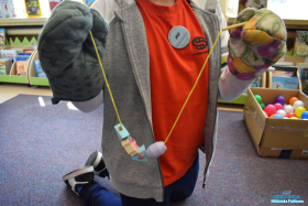 Chłopiec prezentuje klocki zawieszone na sznurku