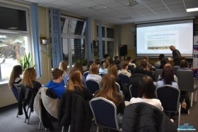 Młodzież siedzi i słucha prelekcji