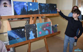 Chłopiec wskazuje dłonią na jeden z obrazów