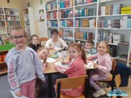 Pani z dziećmi siedzi przy stoliku