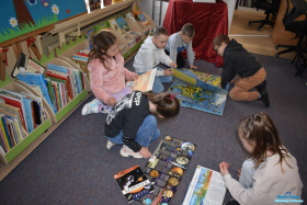 Dzieci siedzą na podłodze i oglądają książki