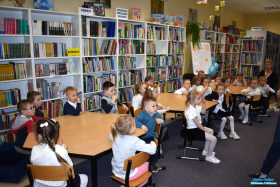 Dzieci siedzą przy stolikach