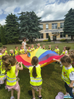 Dzieci wraz z Panią trzymają kolorową chustę