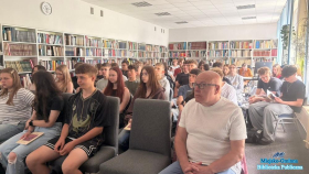 Duża grupa młodych osób siedzących w dużej sali