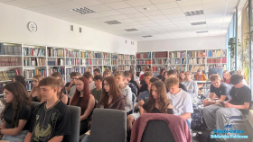 Grupa młodych osób siedzących w dużej salo