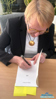 Kobieta wpisująca dedykację w ksiązkę MY