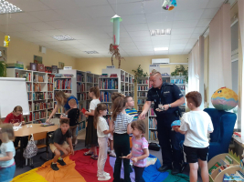 Policjant rozdający dzieciom ulotki