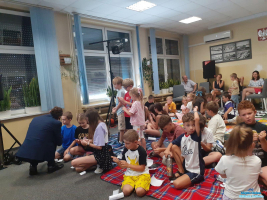 Pan przykucnął przy dzieciach, które wykonują sztuczki