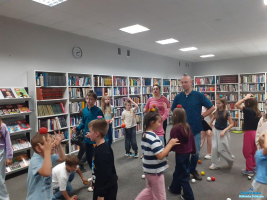 dzieci-chodz-po-dzieci chodzą po dywanie z piłeczkami na głowie-z-pieczkami-na-gowie