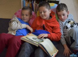 Trzech chłopców ogląda książkę