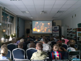 Dzieci siedzą i oglądają film