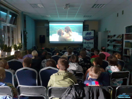 Dzieci siedzą i oglądają scenę z filmu