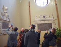 Kilka osób robi zdjęcia epitafium w kościele