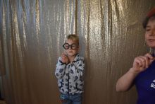 Mały chłopczyk pozuje do zdjęcia z rekwizytem okularów