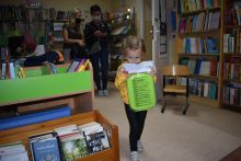 Mała dziewczynka stoi obok biura w bibliotece 