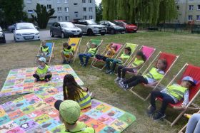 Dzieci siedzę na kolorowych leżakach